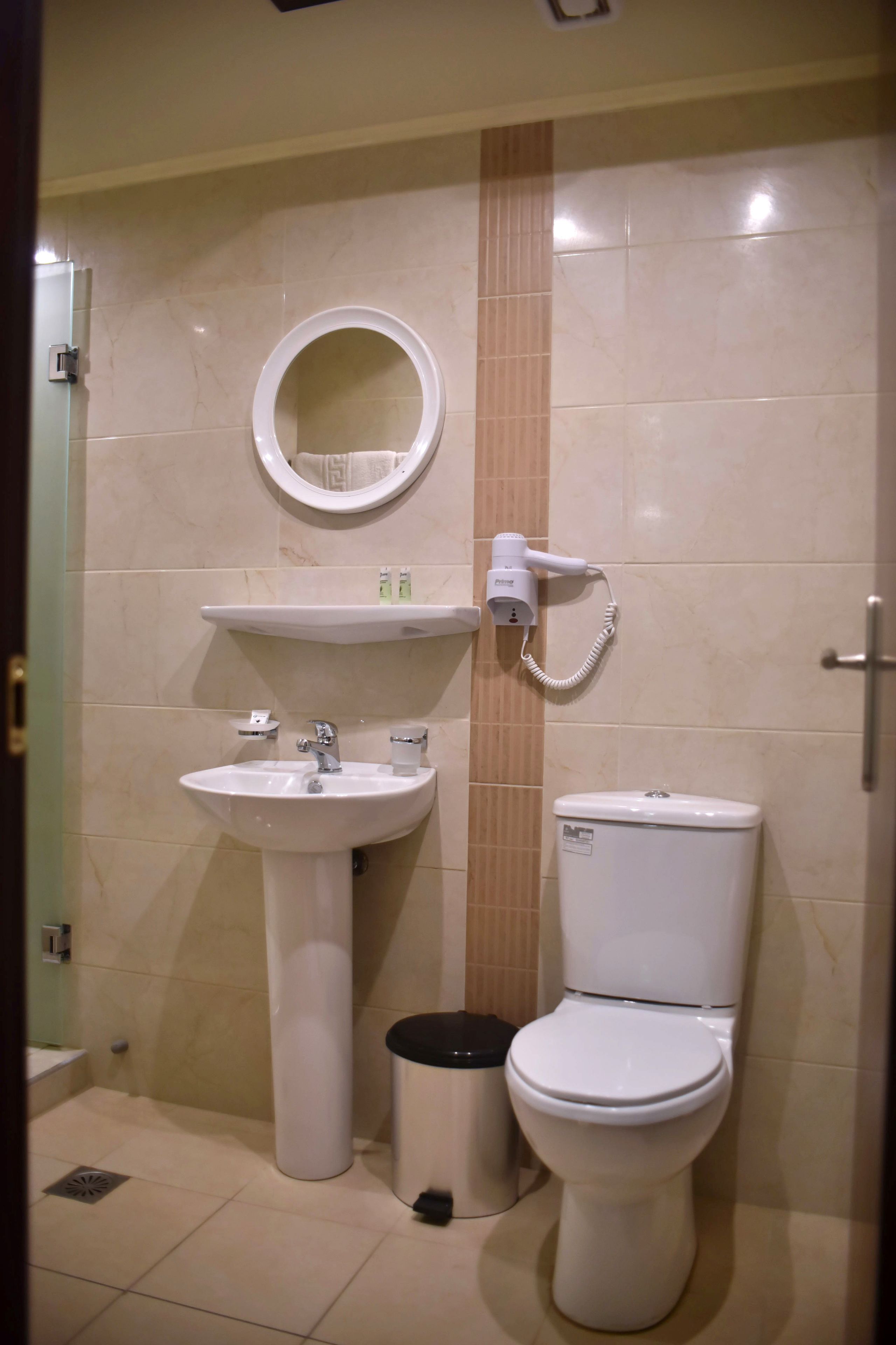 Un bagno con lavandino, specchio, servizi igienici e asciugacapelli.