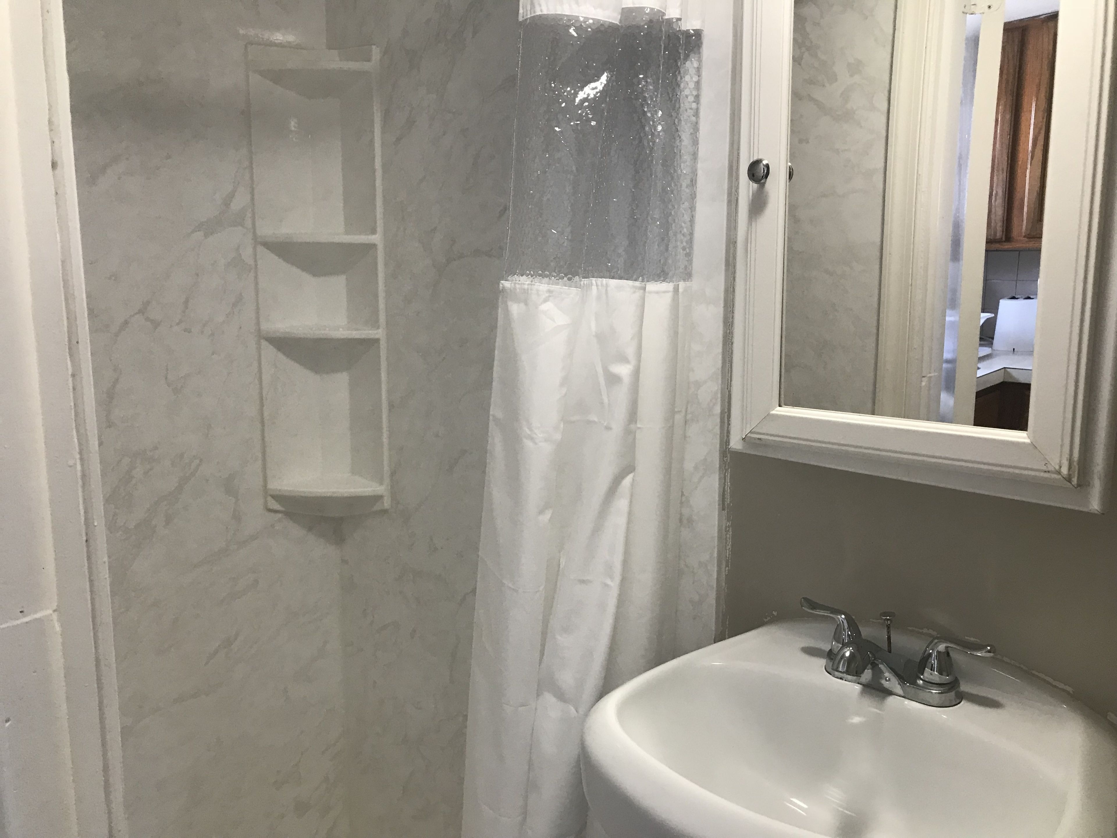 A bathroom with a white sink, a mirror, and a shower curtain.