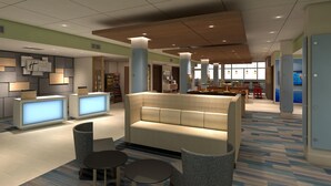 A modern hotel lobby with a reception desk, seating area, and a large window providing natural light. - Holiday Inn Express & Suites Sioux City North-Event Center by IHG (North Sioux City)