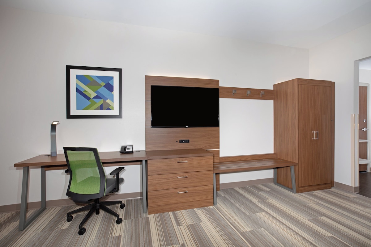 A modern office space with a desk, chair, and wardrobe.