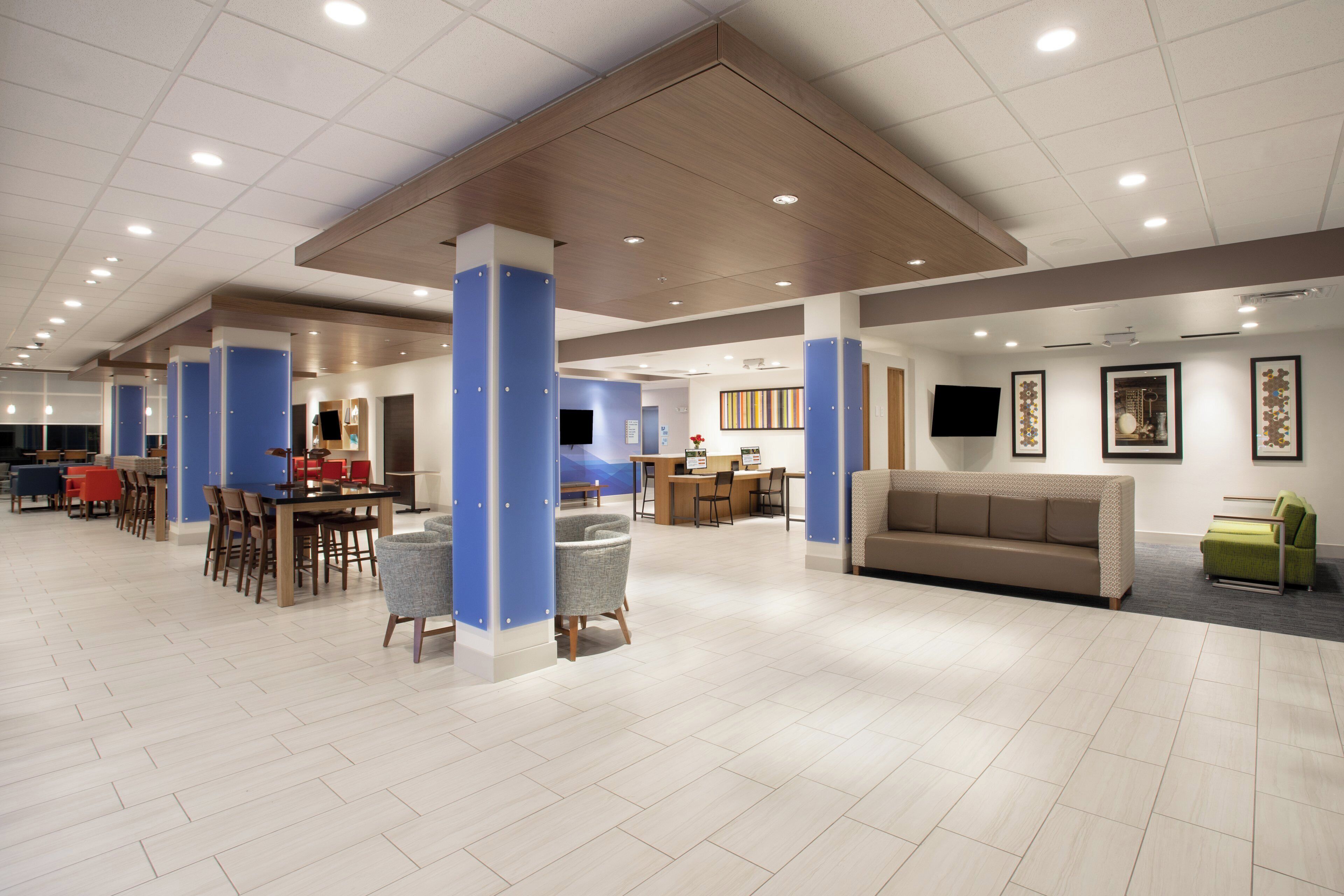 A spacious lobby with a reception desk, seating area, and a television mounted on the wall.