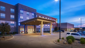 A hotel with a covered entrance, stone pillars, and a parking lot with cars. - Holiday Inn Express & Suites Sioux City North-Event Center by IHG (North Sioux City)