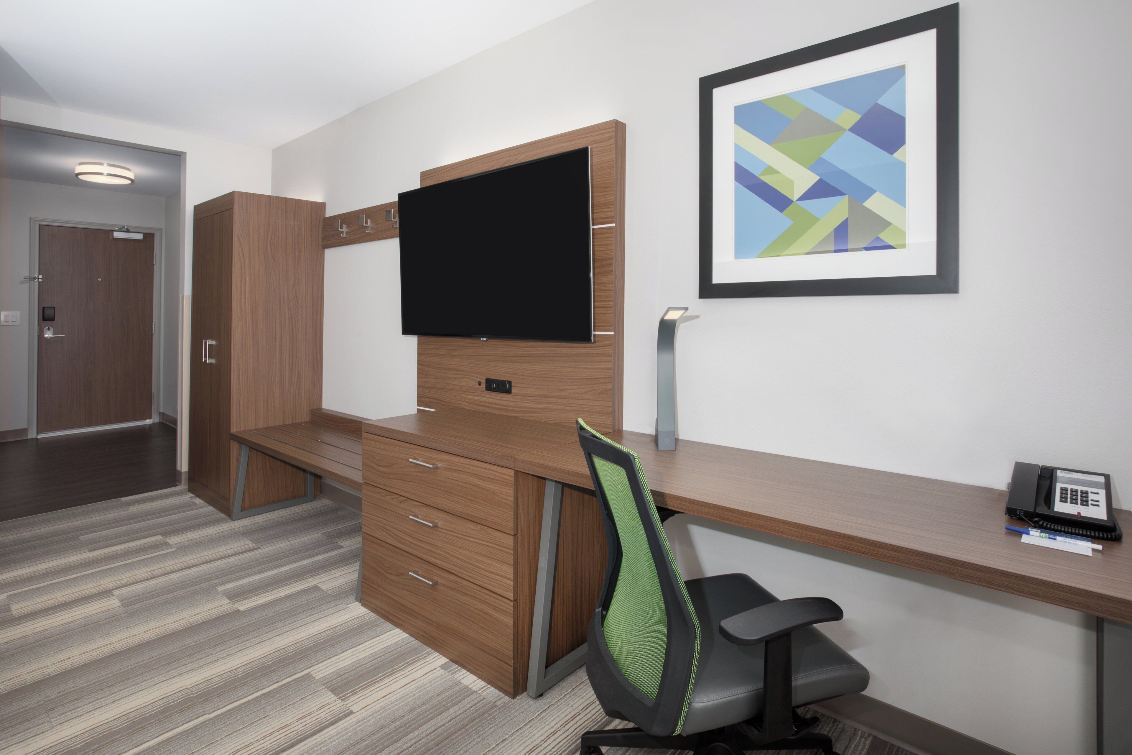 A modern office space with a desk, chair, and a flat-screen monitor.