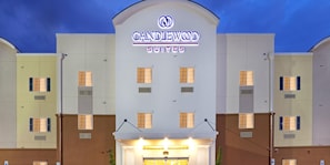 A hotel with a prominent "CANDLEWOOD SUITES" sign, multiple windows, and a flat facade.