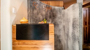 A reception desk with a wooden finish and a black marble top. Above the desk, the text "DC Spa" is visible. - Hotel DC Boutique & SPA (Puerto Escondido)