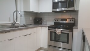 Condo, balcón | Cocina privada | Refrigerador, microondas, horno y parrilla de estufa 