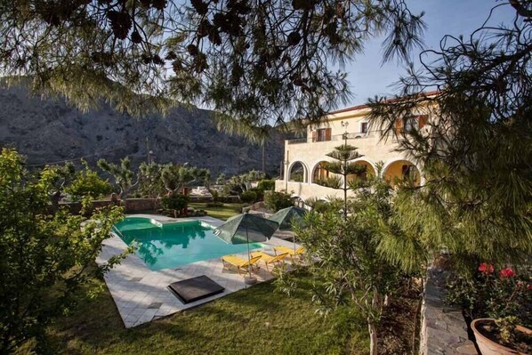 Una piscina al aire libre, sombrillas, tumbonas