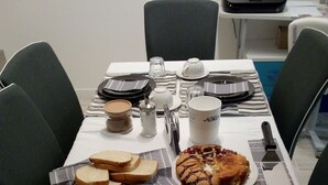 A dining table set with bread, jam, a cake, and condiments. - Bed and Breakfast Bio Salix (Padova)