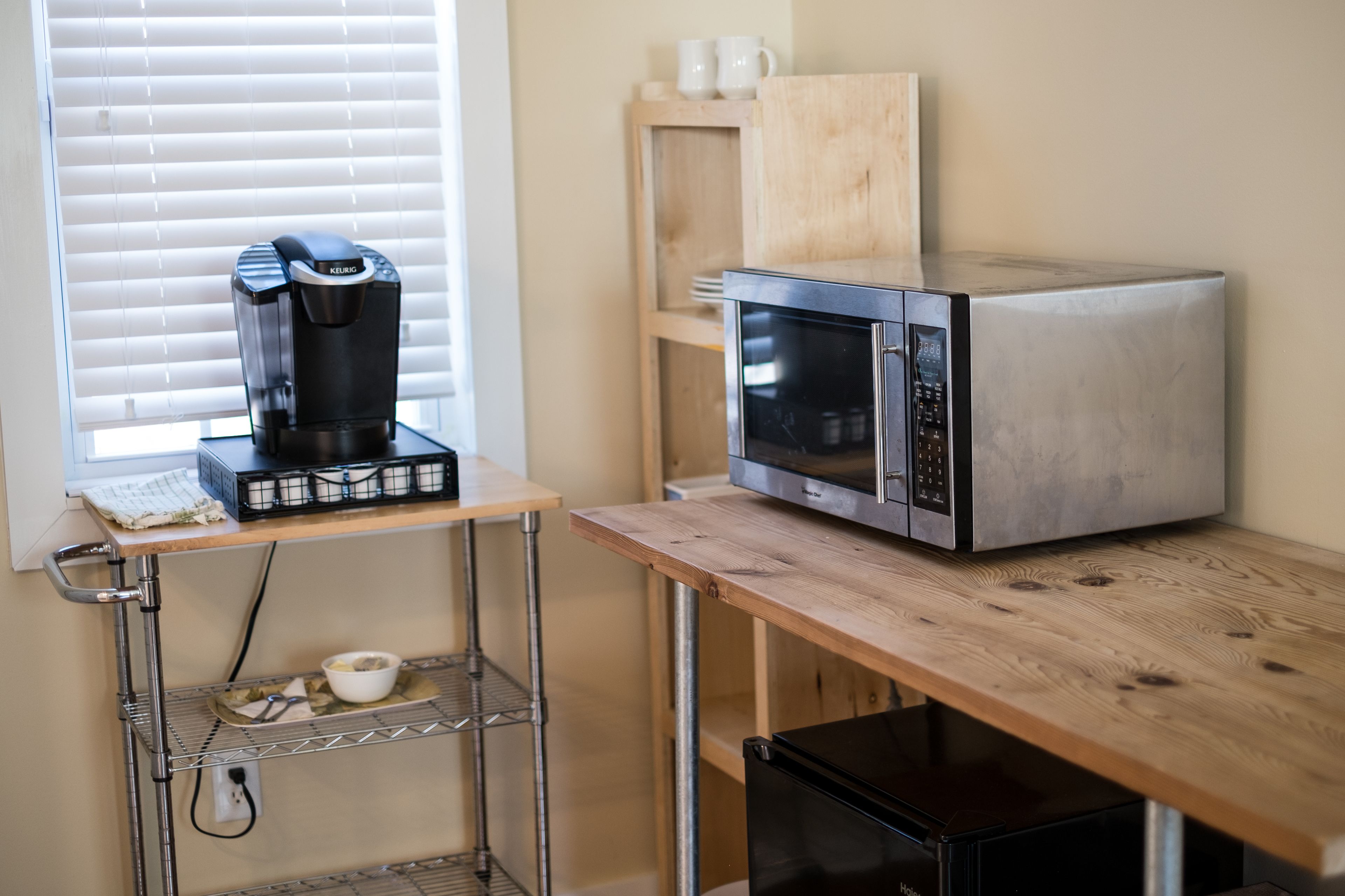 A kitchenette with a coffee maker, microwave, and a small refrigerator.