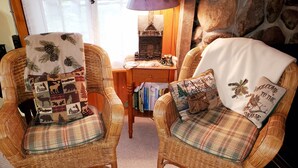 Two wicker chairs with plaid cushions, a small wooden table with books, and a welcome mat. -  Perfect getaway for couples ! close to Ludington!

 (Fountain)