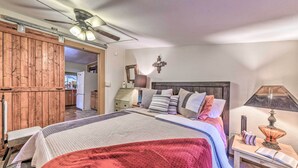 Un dormitorio con cama, mesita de noche, lámpara y un armario de madera.