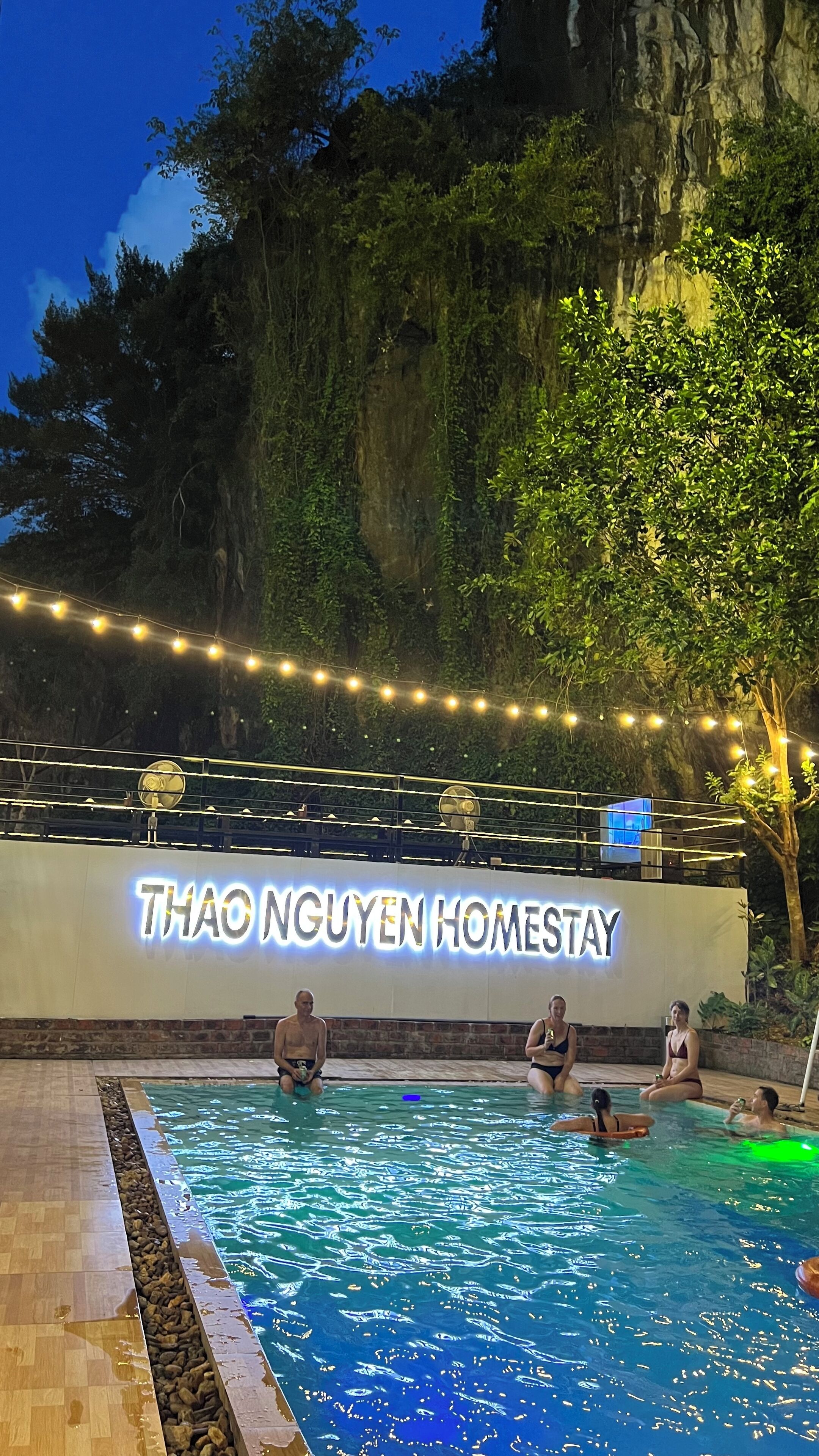 Un espace piscine avec une pancarte indiquant « THAO NGUYEN HOMESTAY ».