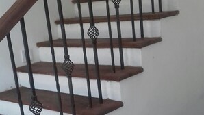 A staircase with wooden steps and black metal railings with decorative elements. - Padmasiri Holiday Resort (Anuradhapura)