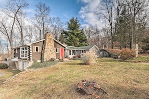 A log cabin with a stone chimney, a red door, and a stone porch. - Macungie Cabin w/ Fireplace Near Bear Creek Skiing (Macungie)