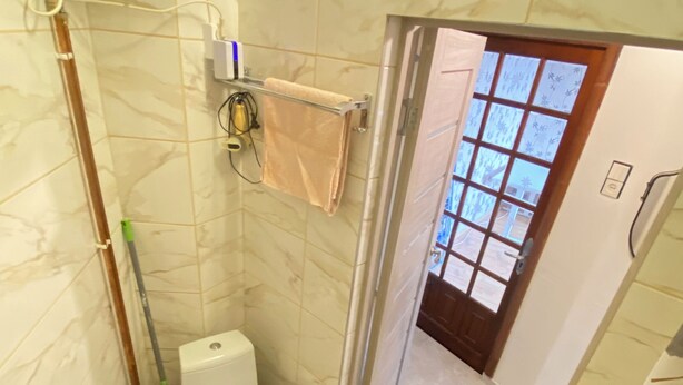 Een badkamer met toilet, wastafel en douche.
