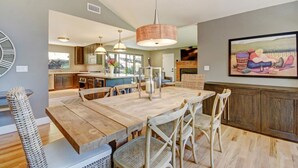 A spacious kitchen with a large island, wooden dining table, and wicker chairs. - Sonoma Vineyard Estate - 3bd/2bth (Sonoma)
