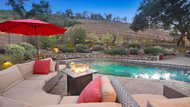 A pool area with a fire pit table, outdoor furniture, and a red umbrella. - Sonoma Vineyard Estate - 3bd/2bth (Sonoma)