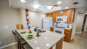 A kitchen with a granite countertop, wooden cabinets, a built-in oven, and a microwave.