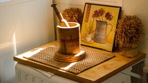 A kitchen counter with a wooden mortar and pestle, a woven placemat, and a framed picture of a flower vase. - Mykonos Town Panorama with Private Terrace  (Mikonos)
