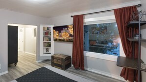 A room with a window, a bookshelf, a small wooden chest, and a rug. - The Immaculate Guest Cottage In Downtown Coeur  D'Alene (Coeur d'Alene)