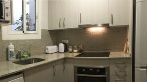 Uma cozinha compacta com lava-louças, forno e fogão embutido.