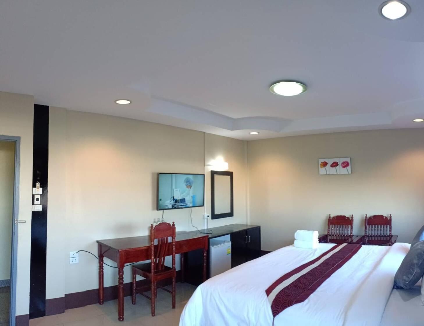 Una habitación de hotel con cama, escritorio, silla y televisión.