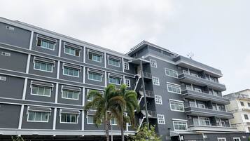 Un edificio de varios pisos con un diseño arquitectónico moderno, con balcones y ventanas amplias.