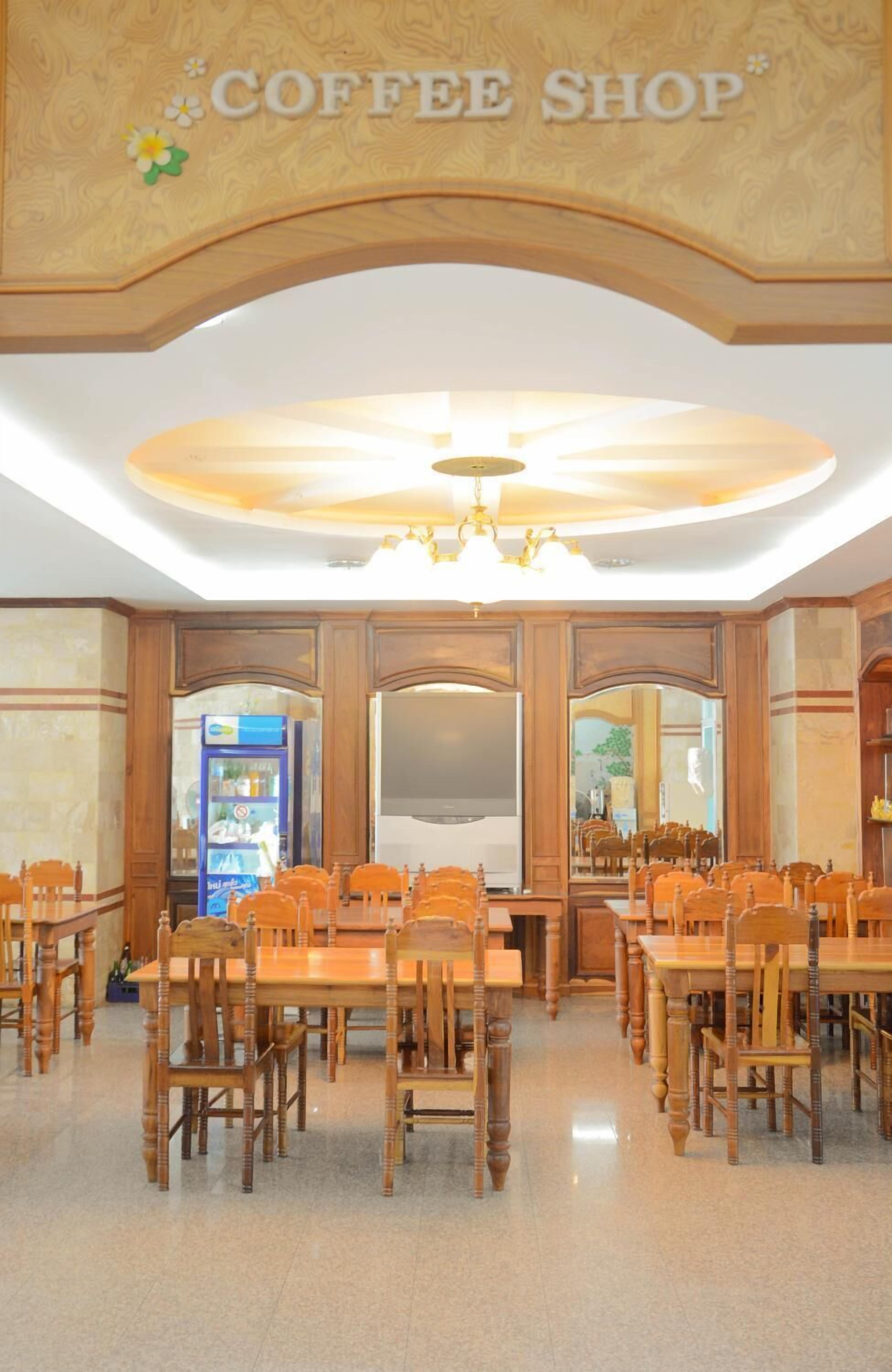 A coffee shop with wooden furniture and a chandelier.
