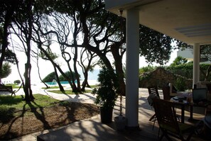 A covered outdoor area with a patio, seating, and a view of the sea. - Dream location- Modern villa with pool by the sea, just a stone's throw from Rome. (Anzio)