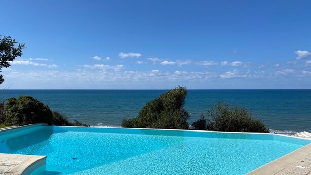 A swimming pool with a clear view of the ocean.