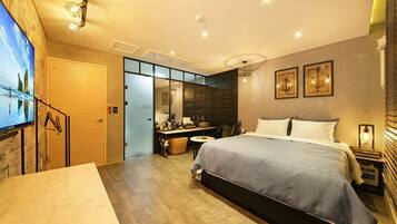 Una habitación de hotel moderna con una cama grande, un escritorio y una zona de estar.