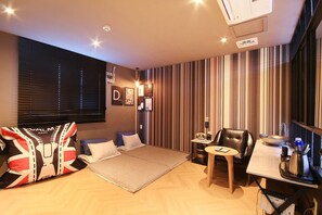 Une chambre moderne avec un lit, un bureau, une chaise et une grande fenêtre équipée de stores.