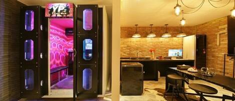 Um interior moderno com área de bar, cozinha com parede de tijolos e sala de estar com piso estampado.