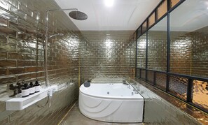 Une salle de bain moderne dotée d’une grande baignoire, d’une cabine de douche en verre et d’une fenêtre donnant sur l’extérieur.