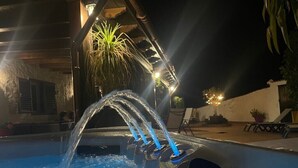 Una piscina con fuente de agua e iluminación.