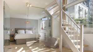 Een moderne slaapkamer met een bed, nachtkastjes en een groot raam.