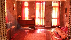 A cozy room with a wooden desk, a television, and a sofa. - The Mapple Cottage (Nainital)