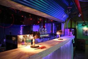 A bar area with a long counter, various bar equipment, and a ceiling with exposed pipes and lighting. - gangneung sol guesthouse - Hostel (Gangneung)