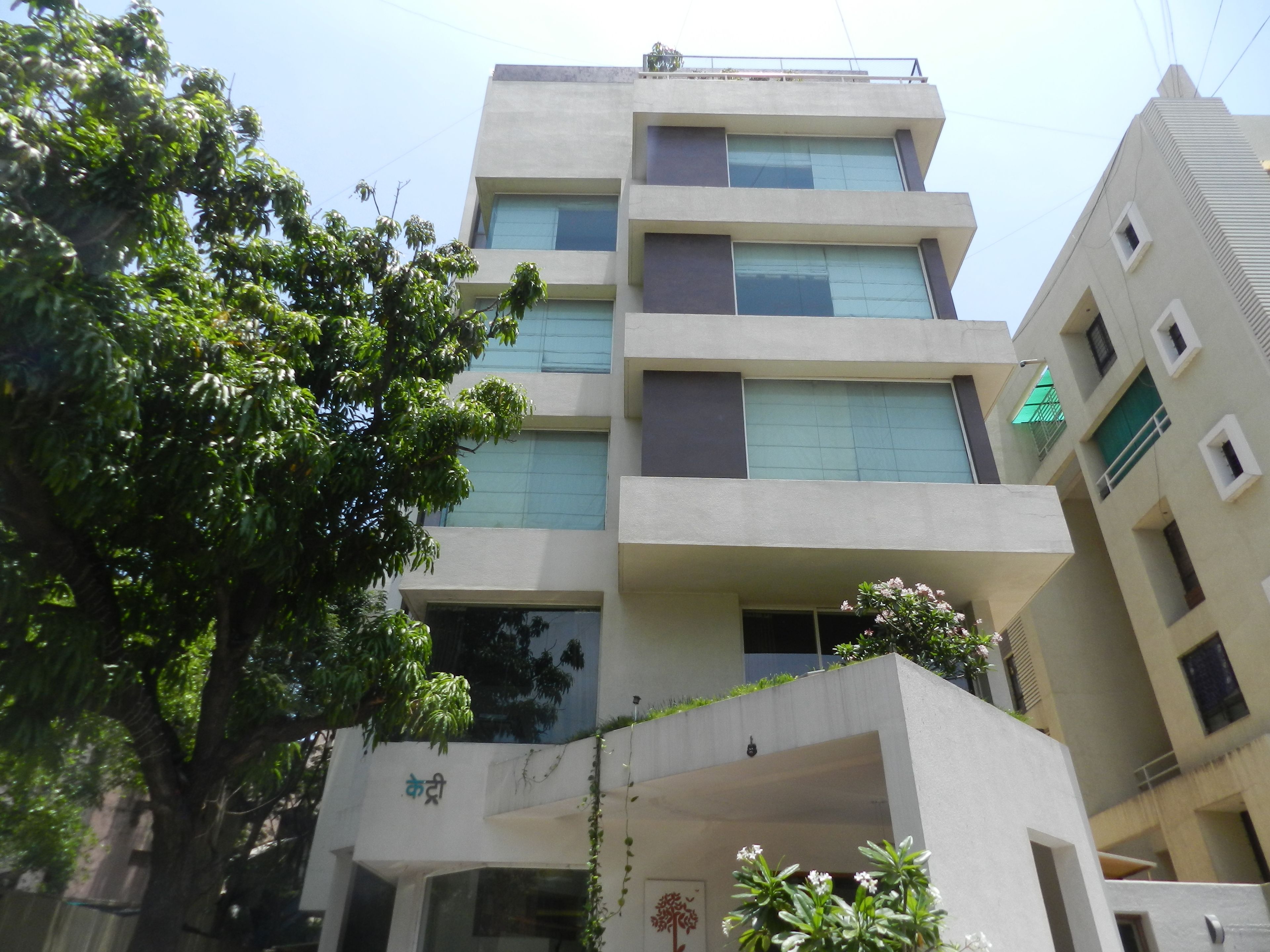 A multi-story building with a flat facade, large windows, and balconies.