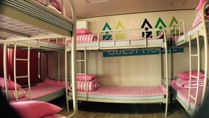 A bunk room with bunk beds, a ladder, and a wall with geometric patterns. - Donghae Sol Guesthouse - Hostel (Donghae)