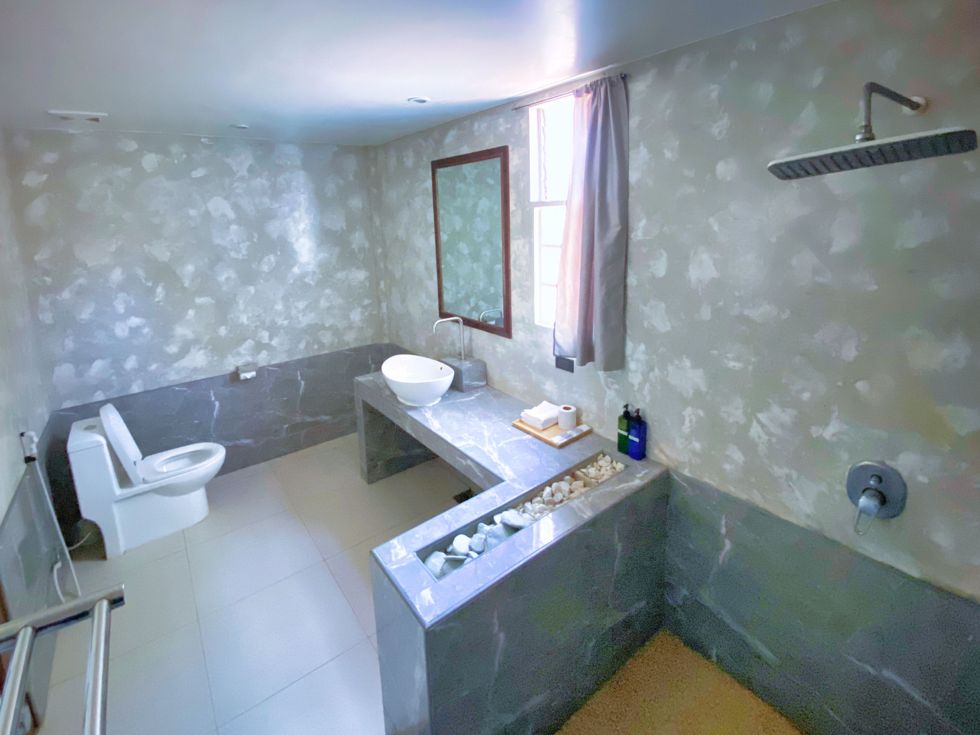A bathroom with a toilet, sink, and shower.