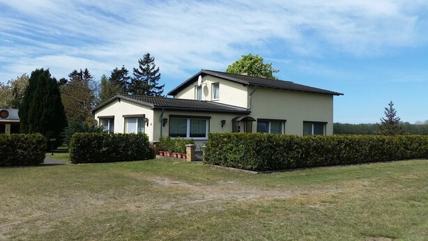 A two-story house with a flat roof, large windows, and a well-maintained lawn. - 2-R-Whg. Labahn 1 - House Labahn (Korswandt)