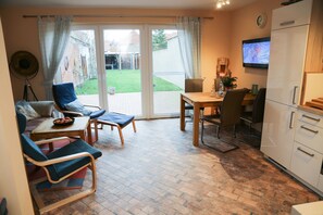 Relax in this inviting space with a sofa, chairs, and dining table, perfect for unwinding and enjoying meals.