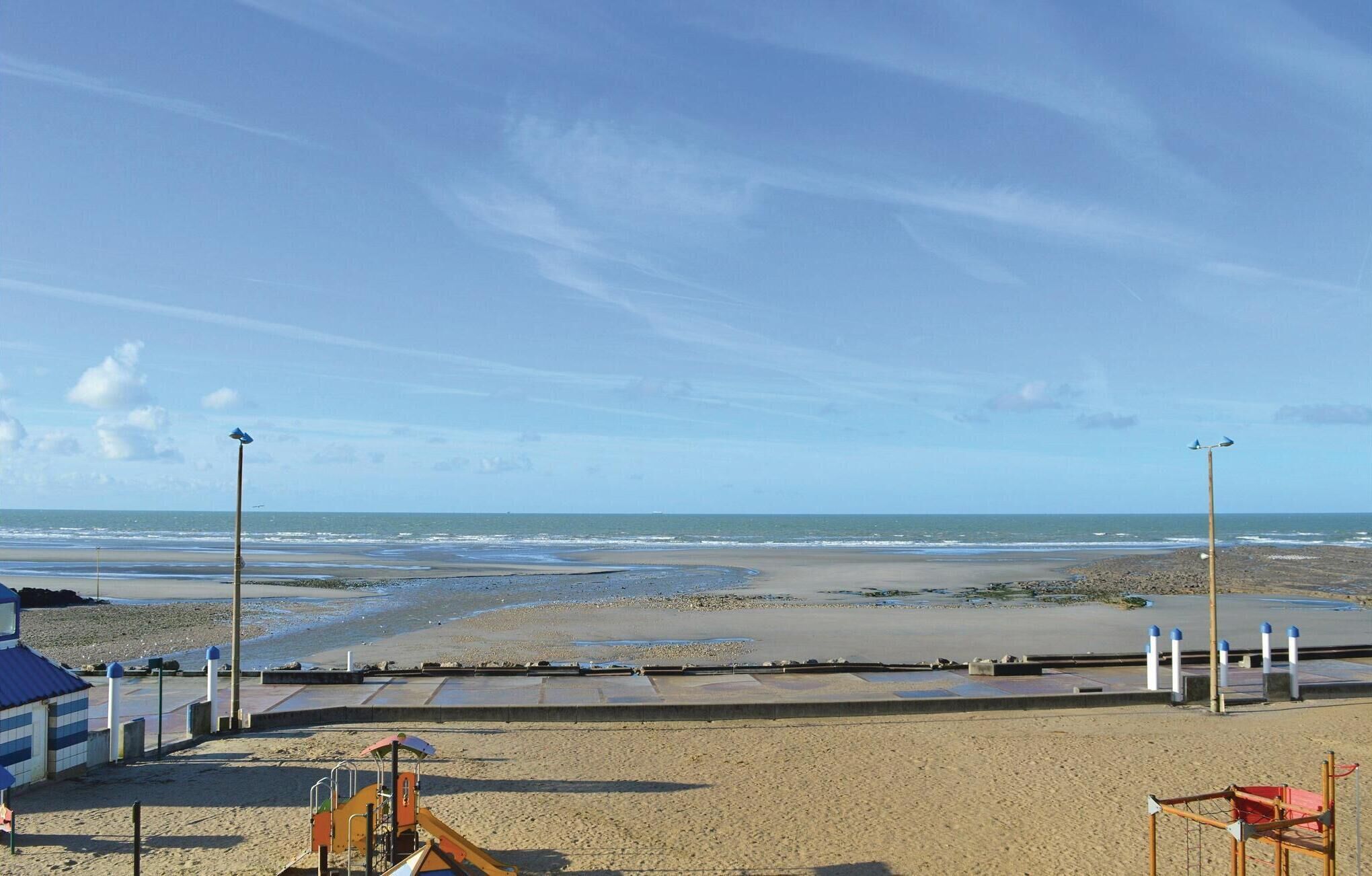 A beach with a lifeguard tower, a playground, and a sandy shore.
