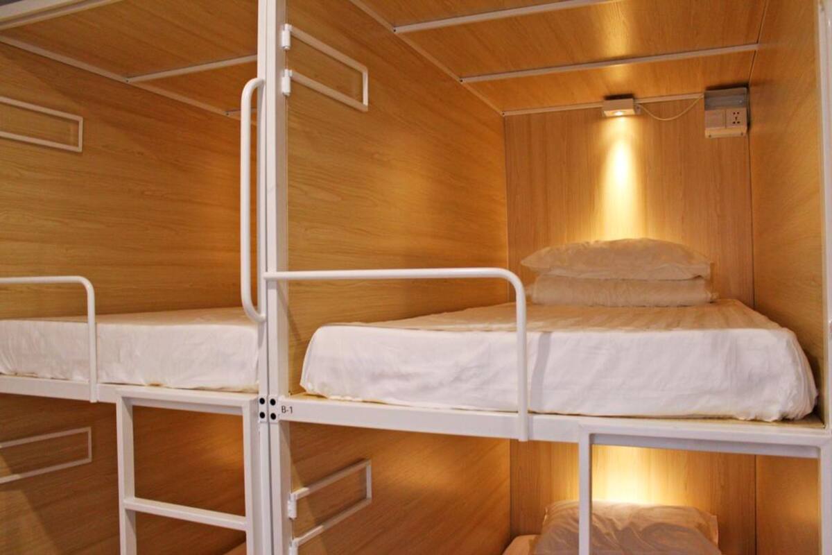 A bunk bed room with wooden walls and a single light fixture above the bed.