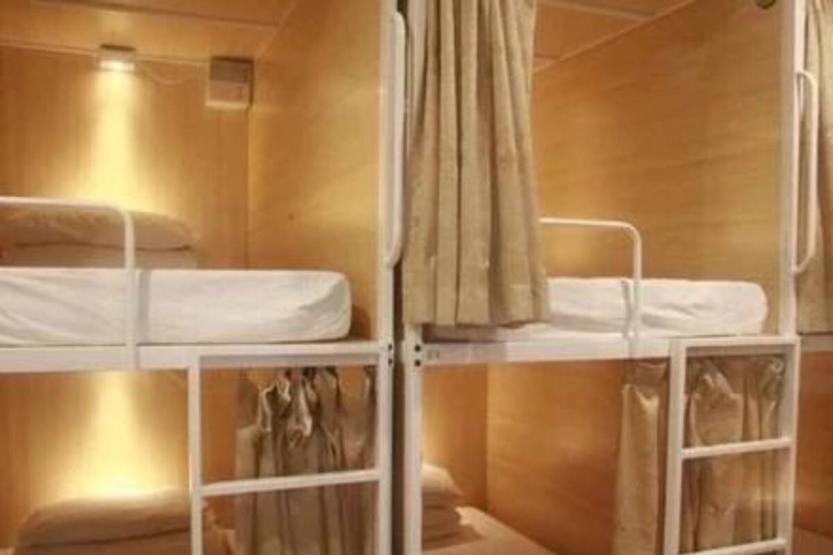 A bunk bed room with a wooden interior, a small window, and a curtain.