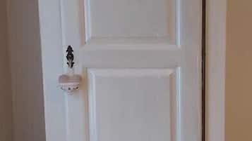 A white, double-door cabinet with a small decorative item on the left door.