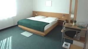 A hotel room with a bed, bedside table, and a mirror. - App. 25 - Apartment house Anne (Binz)