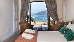 A bedroom with a bed, a view of the sea, and a balcony. - Moncrieff Manor (Knysna)