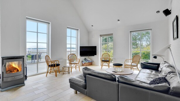 Un salón amplio con chimenea, ventanas grandes, un sofá y un televisor.